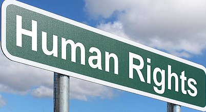 Menschenrechte und menschenrechtliche Sorgfaltspflichten Schild mit der Aufschrift „Human Rights“ vor blauem Himmel. Das Bild steht im Kontext der internationalen Debatte über menschenrechtliche Sorgfaltspflichten von Unternehmen und den Schutz von Menschenrechten in globalen Lieferketten.